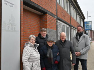Das Foto zeigt von links Gerda Dänekas (als Begleiterin von Albrecht Weinberg), Unternehmer Helmut Wittrock, Ehrenbürger Albrecht Weinberg, Bürgermeister Claus-Peter Horst und Stadtbaurat Jens Lüning vor dem Werkstattgebäude, hinter dem sich das Synagogengrundstück befindet. (Foto: Stadt Leer)
